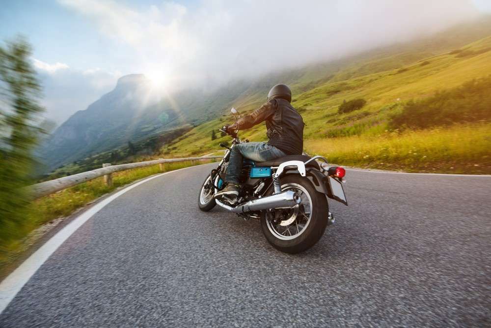 A man is taking a motorcycle road trip to the mountains.